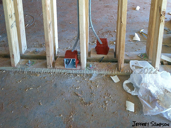 These nonmetallic electrical boxes are installed as membrane penetrations through a fire-rated separation wall between two apartment units and are protected by listed putty pads.